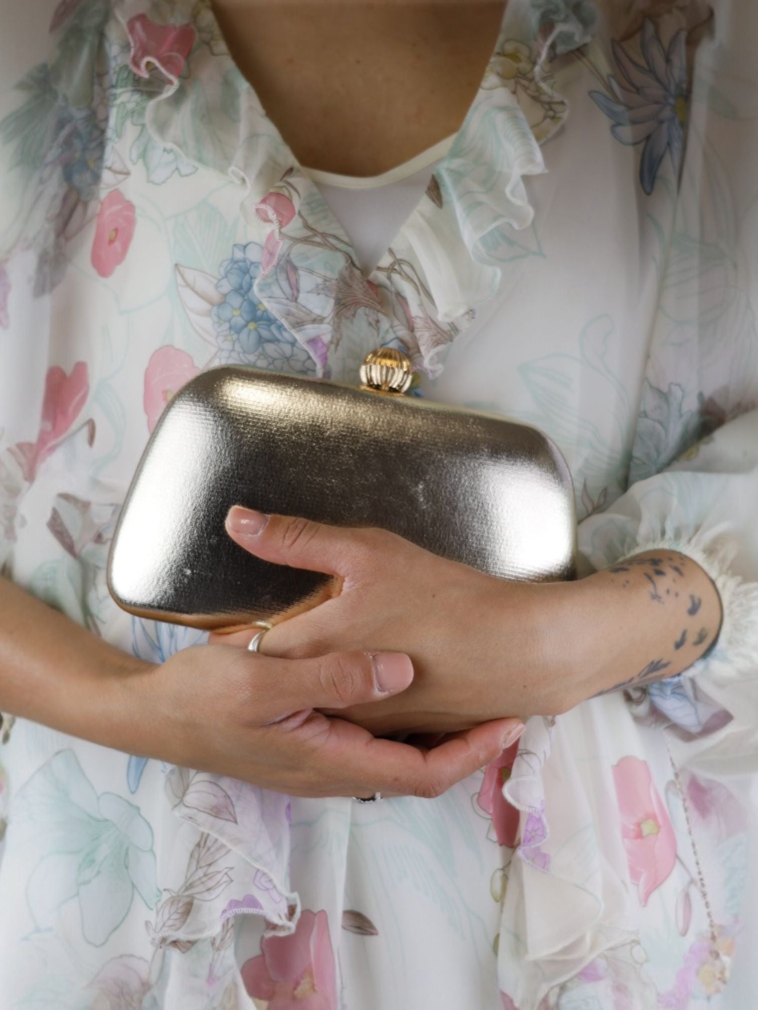 Anna Cecere clutch rigida in laminato oro con chiusura con sfera dorata